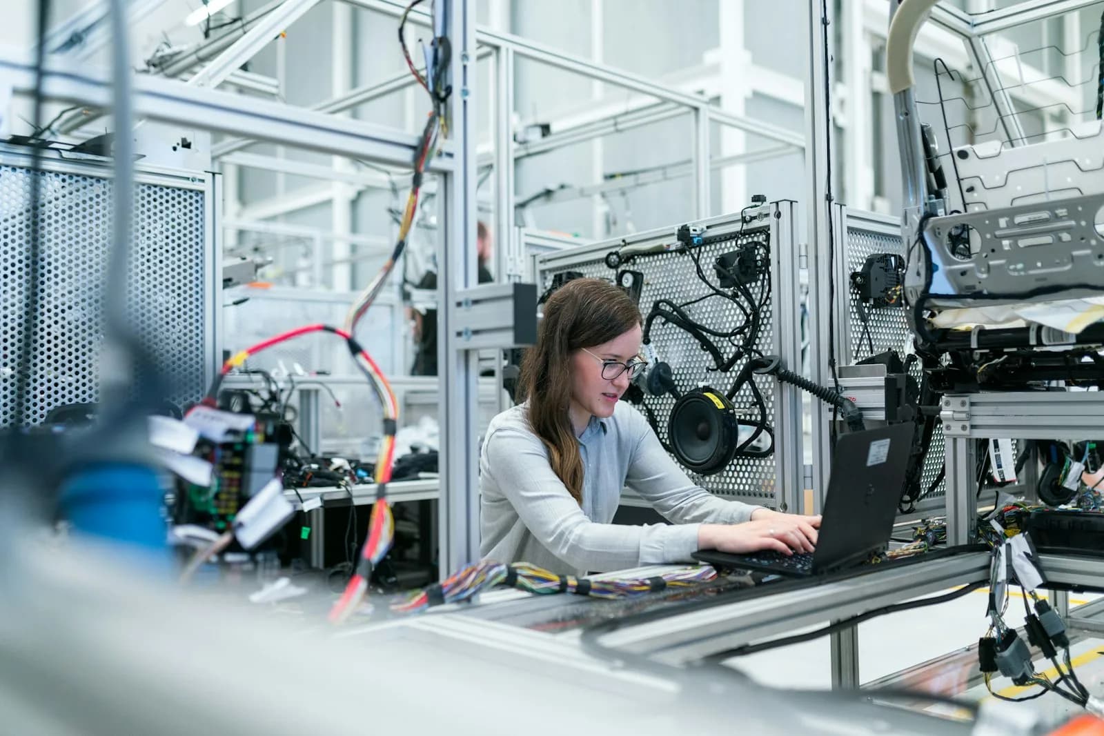 Ingeniera trabajando con laptop en una línea de manufactura